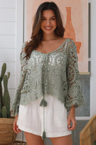 Woman wearing sage crochet boho top with dramatic bell sleeves - festival fashion Australia.