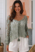 Woman wearing sage crochet boho top with dramatic bell sleeves - festival fashion Australia.