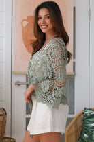 Woman wearing sage crochet boho top with dramatic bell sleeves - festival fashion Australia.
