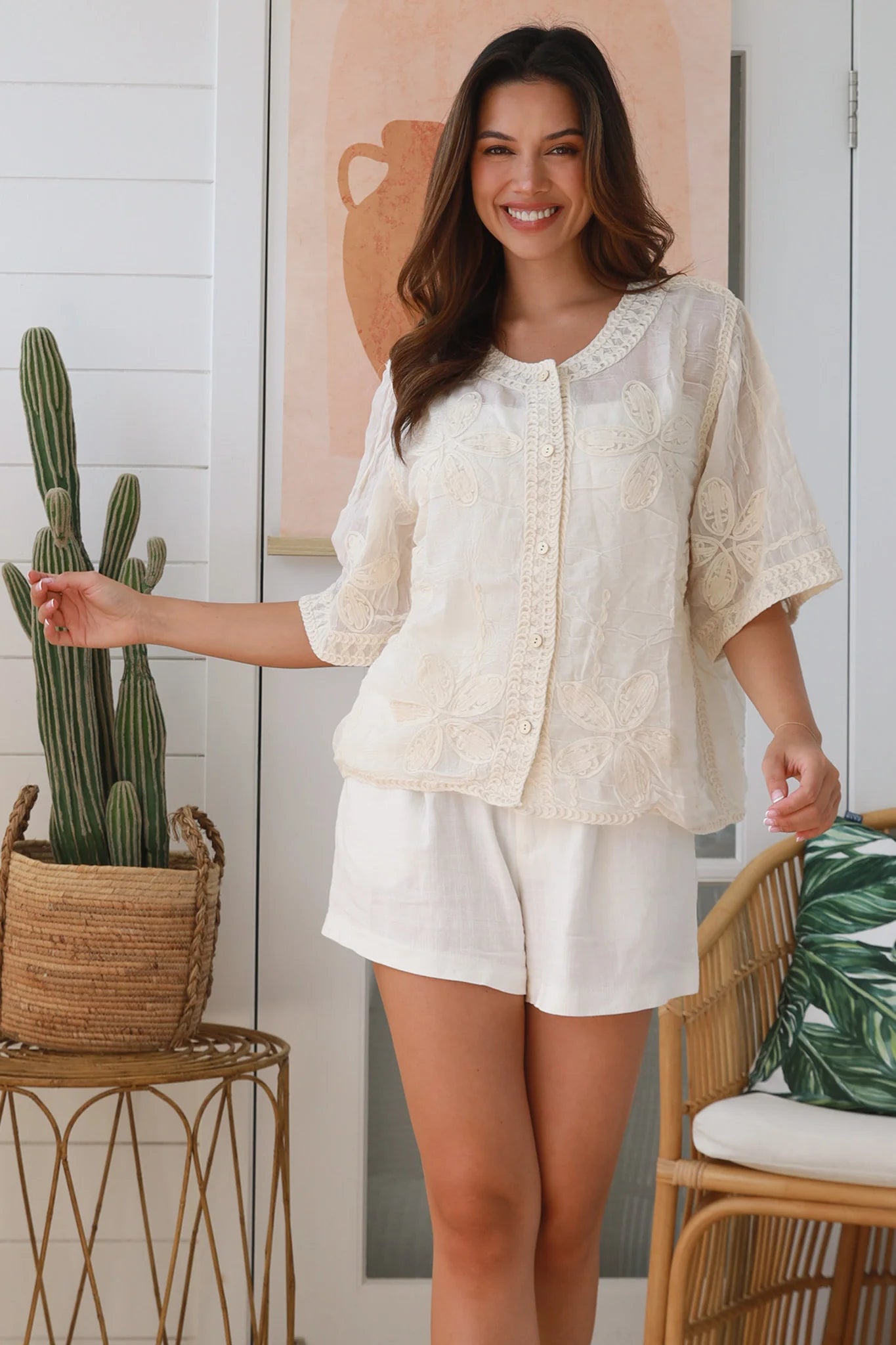 Woman wearing a cream embroidered cotton blouse with artisan trim – Zoe Embroidered Cotton Top Cream.