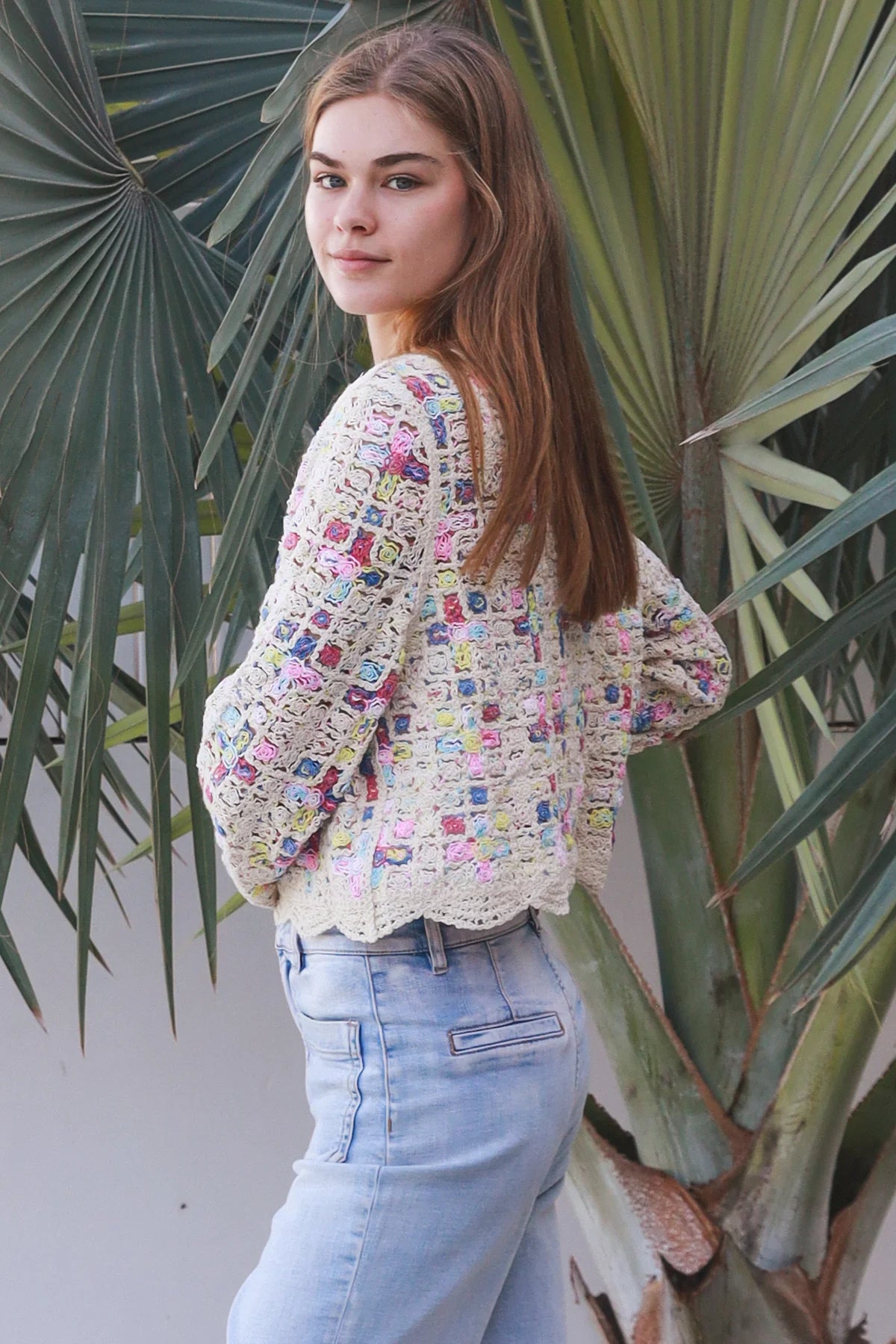 Woman wearing pastel embroidered cotton boho cardigan with textured crochet weave and relaxed vintage - inspired styling in Australia.