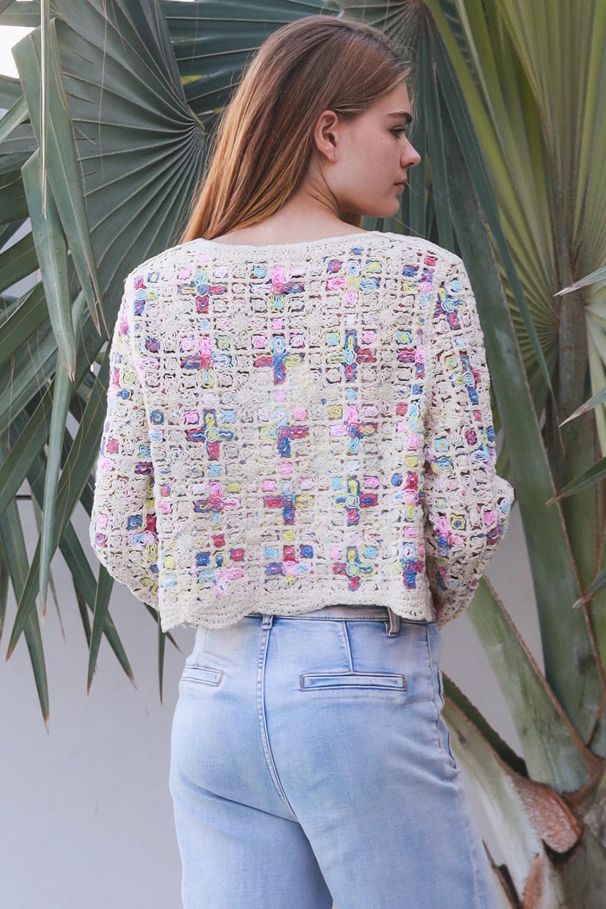 Woman wearing pastel embroidered cotton boho cardigan with textured crochet weave and relaxed vintage - inspired styling in Australia.