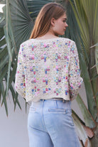 Woman wearing pastel embroidered cotton boho cardigan with textured crochet weave and relaxed vintage - inspired styling in Australia.