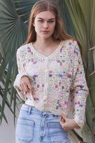Woman wearing pastel embroidered cotton boho cardigan with textured crochet weave and relaxed vintage - inspired styling in Australia.