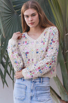 Woman wearing pastel embroidered cotton boho cardigan with textured crochet weave and relaxed vintage - inspired styling in Australia.