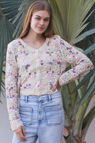 Woman wearing pastel embroidered cotton boho cardigan with textured crochet weave and relaxed vintage - inspired styling in Australia.