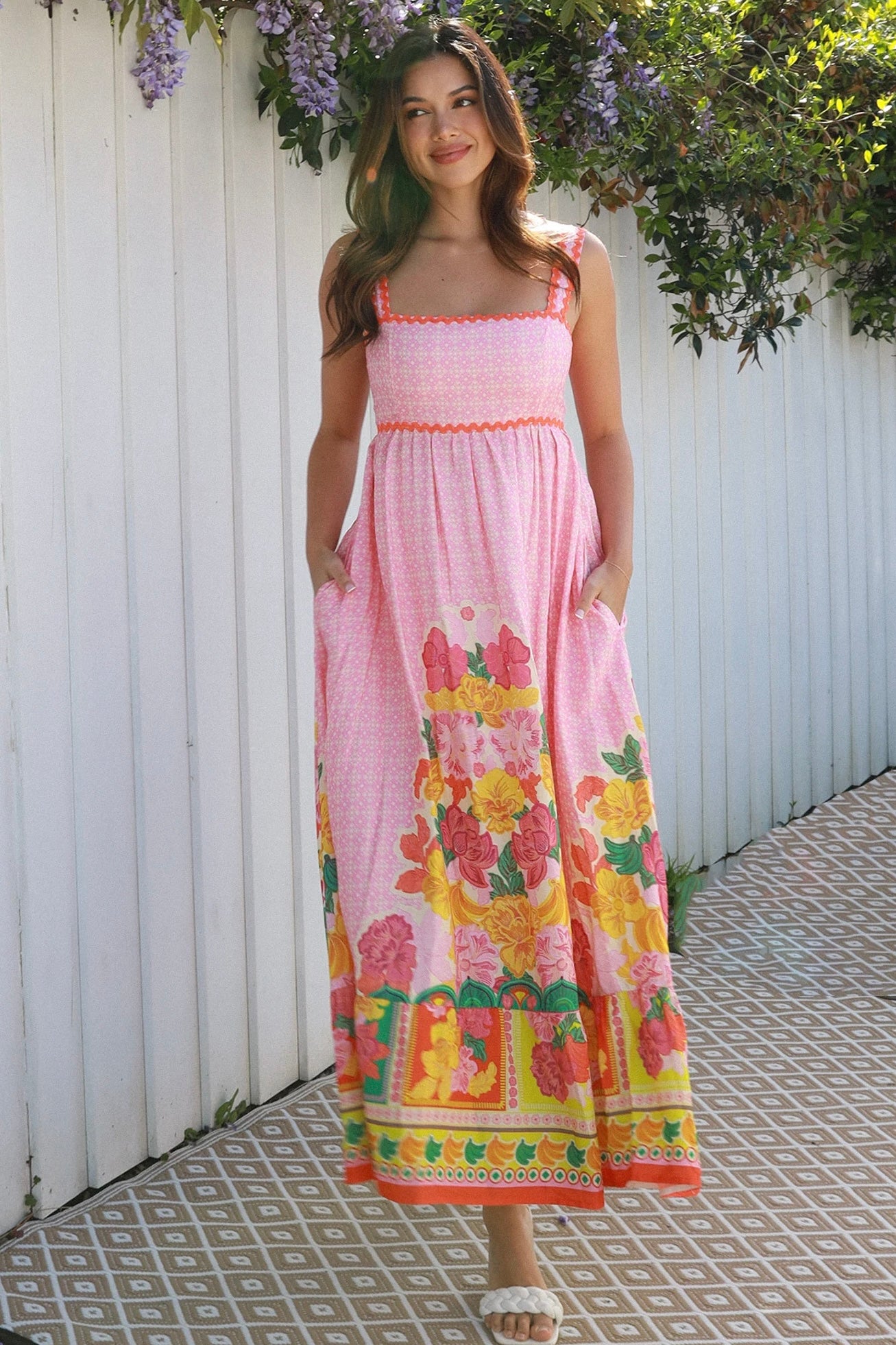 Woman wearing pink floral boho maxi dress with rickrack trim and oversized border hem – Salty Palm