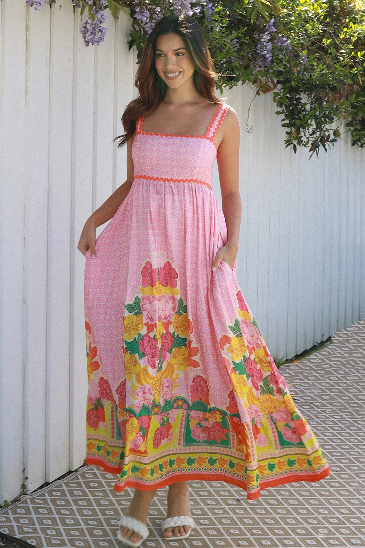 Woman wearing pink floral boho maxi dress with rickrack trim and oversized border hem – Salty Palm