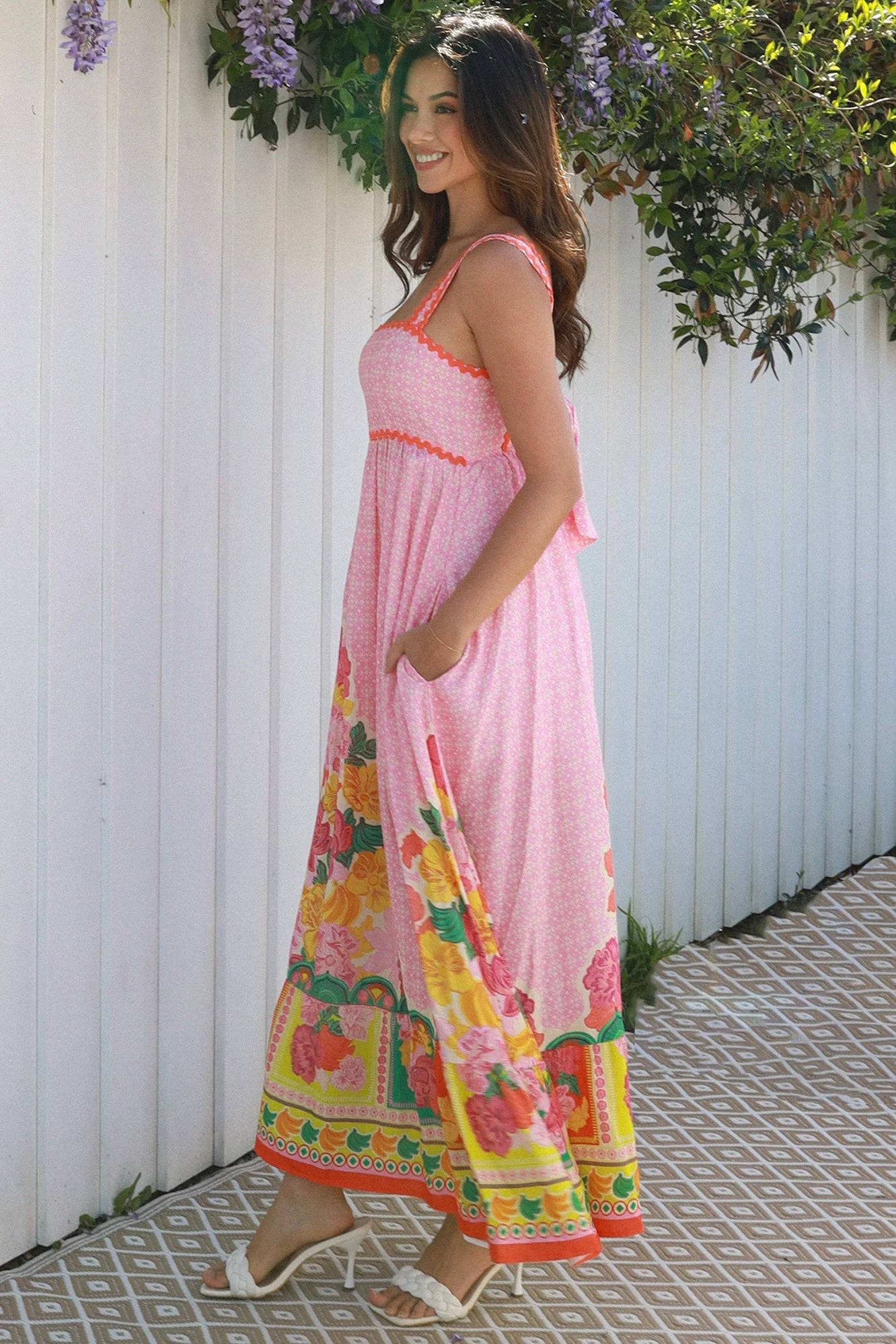 Woman wearing pink floral boho maxi dress with rickrack trim and oversized border hem – Salty Palm