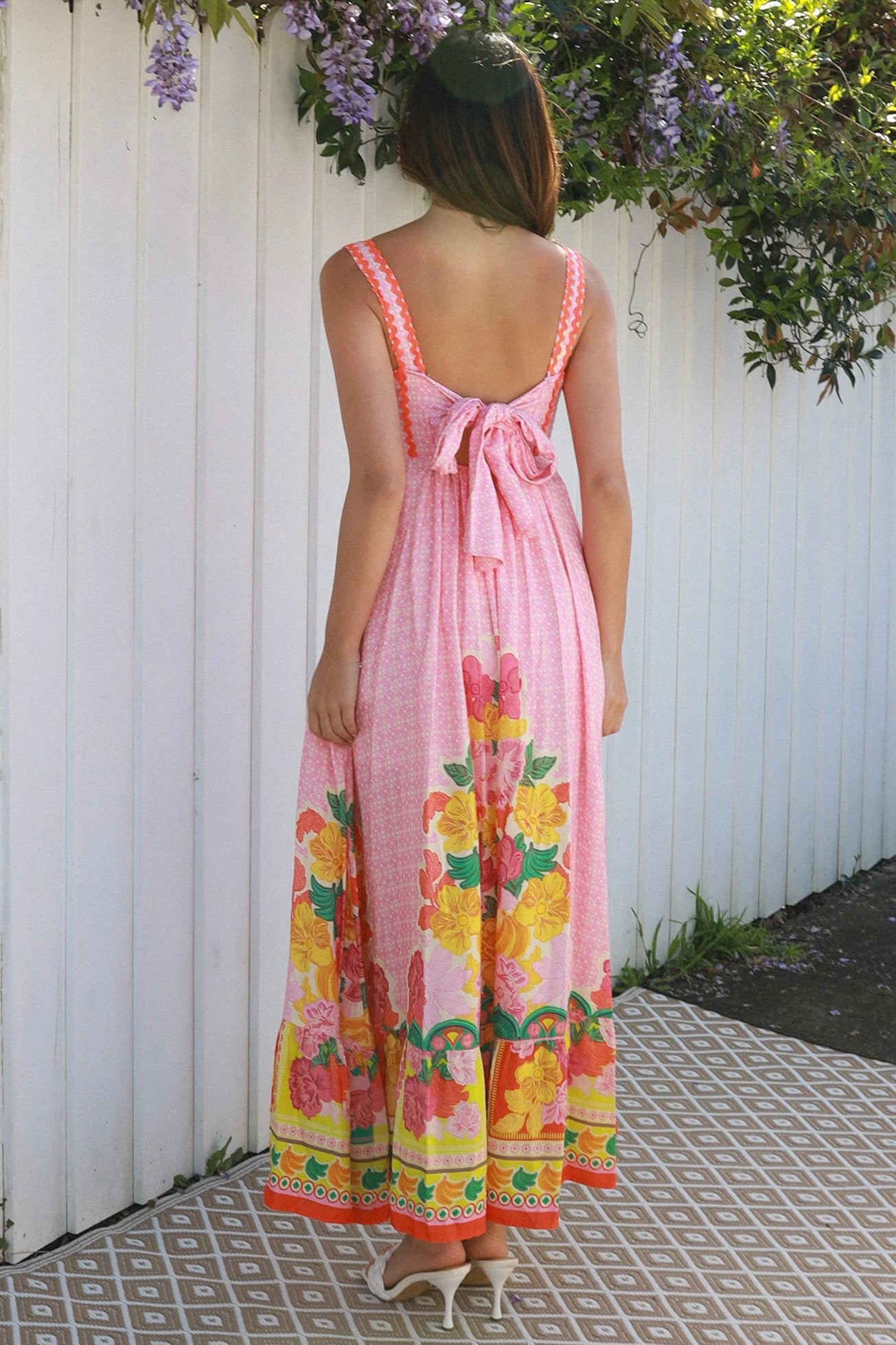 Woman wearing pink floral boho maxi dress with rickrack trim and oversized border hem – Salty Palm