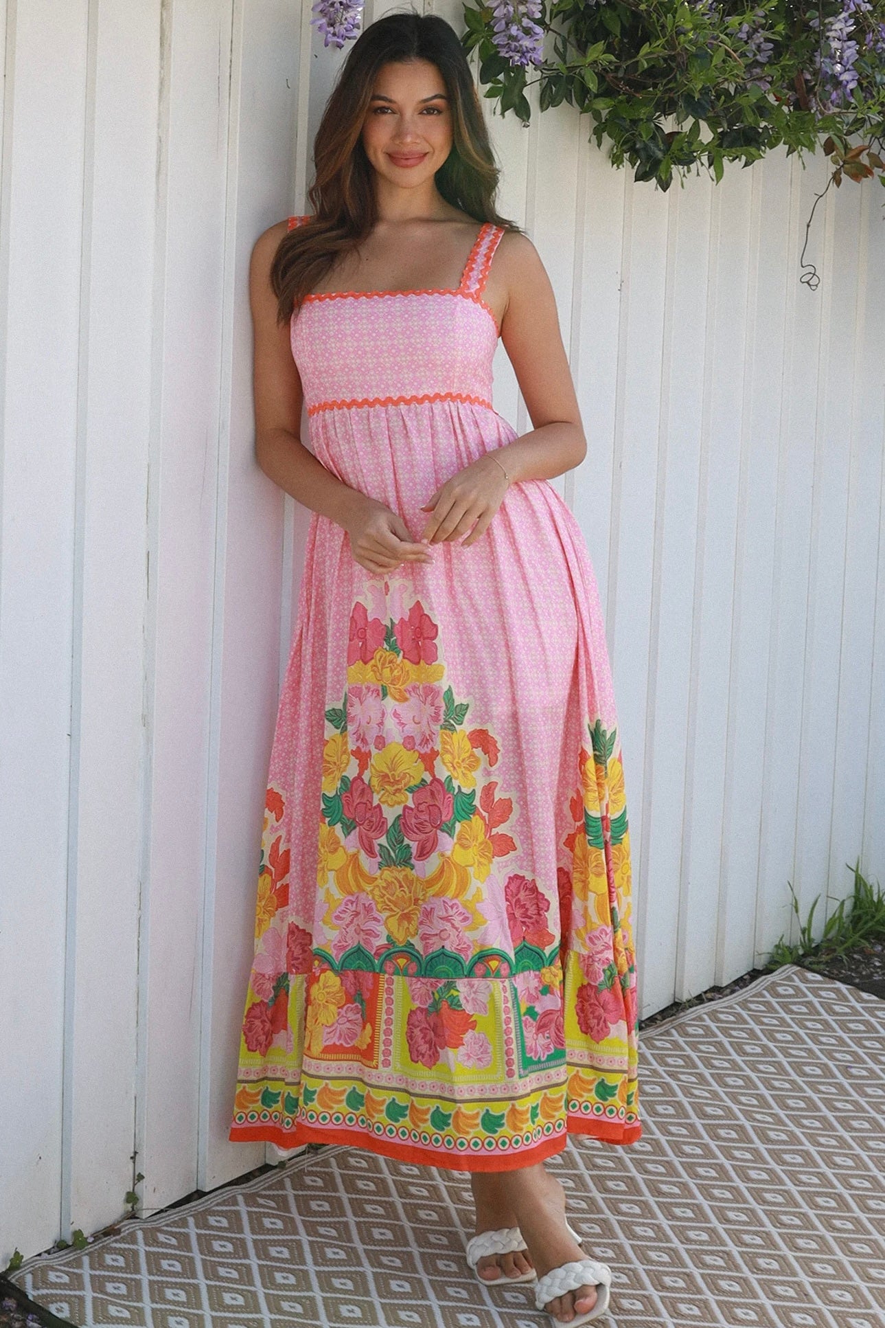 Woman wearing pink floral boho maxi dress with rickrack trim and oversized border hem – Salty Palm