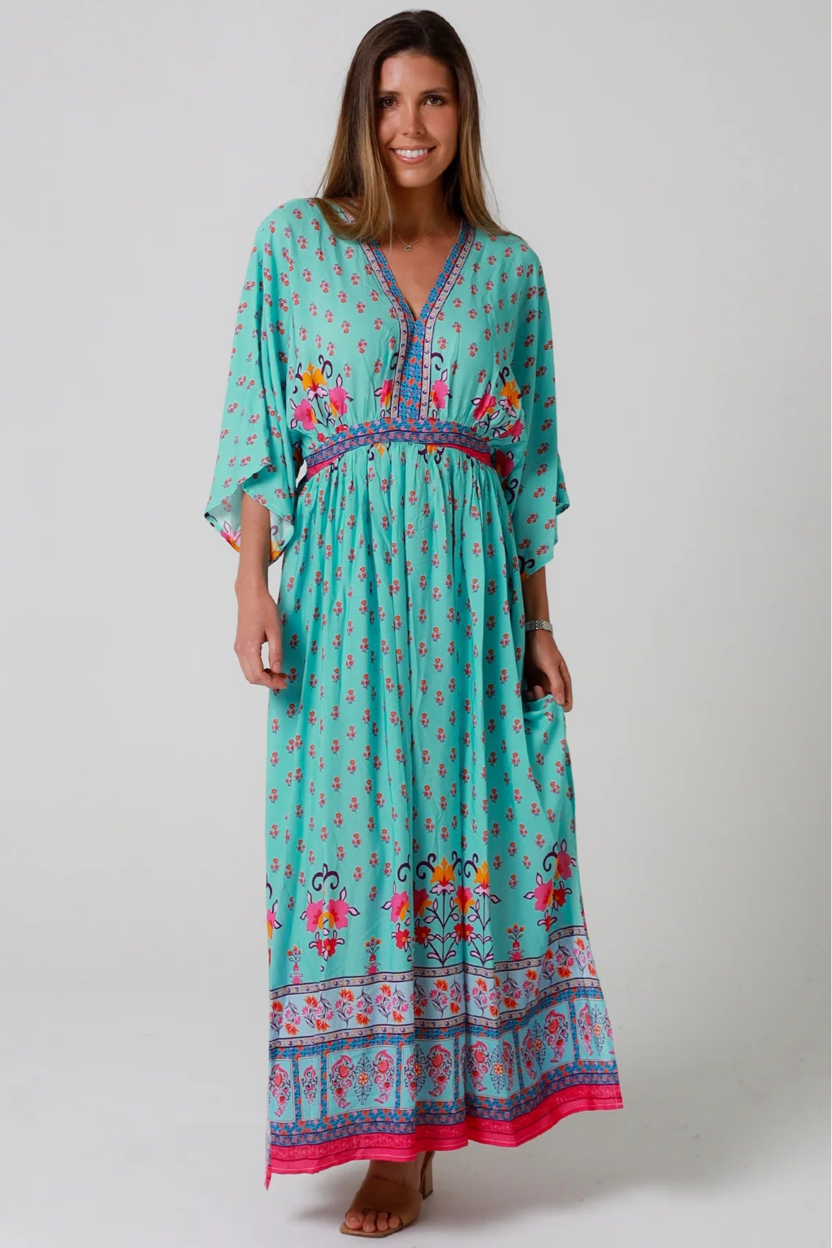 Woman in turquoise floral boho maxi dress with kimono sleeves and border print - Amara Field Maxi Dress Australia.