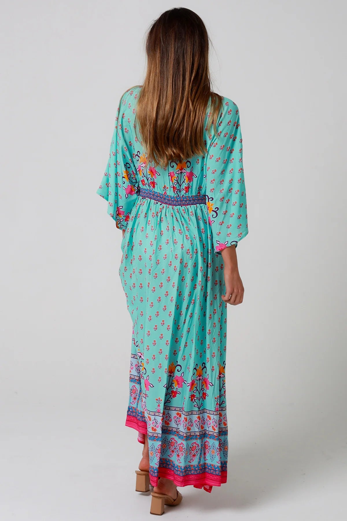 Woman in turquoise floral boho maxi dress with kimono sleeves and border print - Amara Field Maxi Dress Australia.