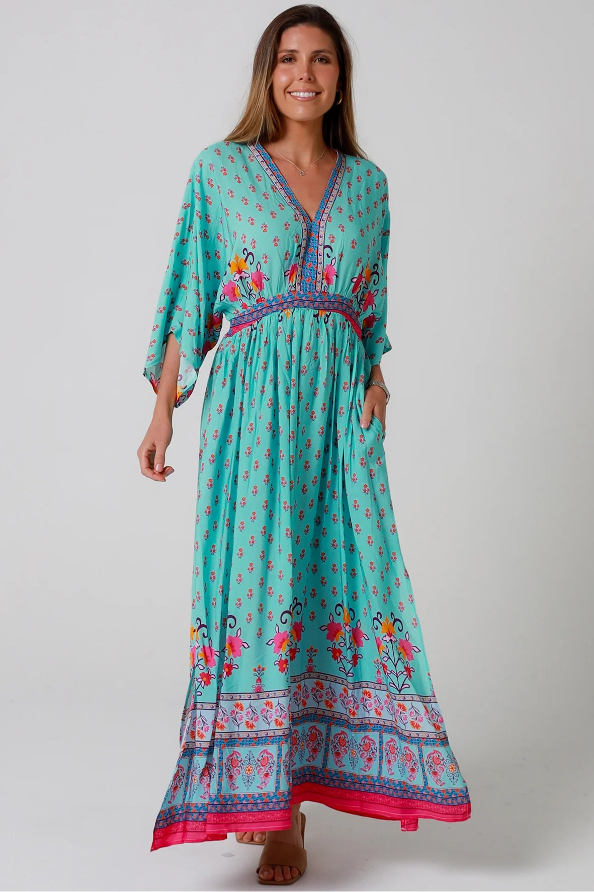 Woman in turquoise floral boho maxi dress with kimono sleeves and border print - Amara Field Maxi Dress Australia.