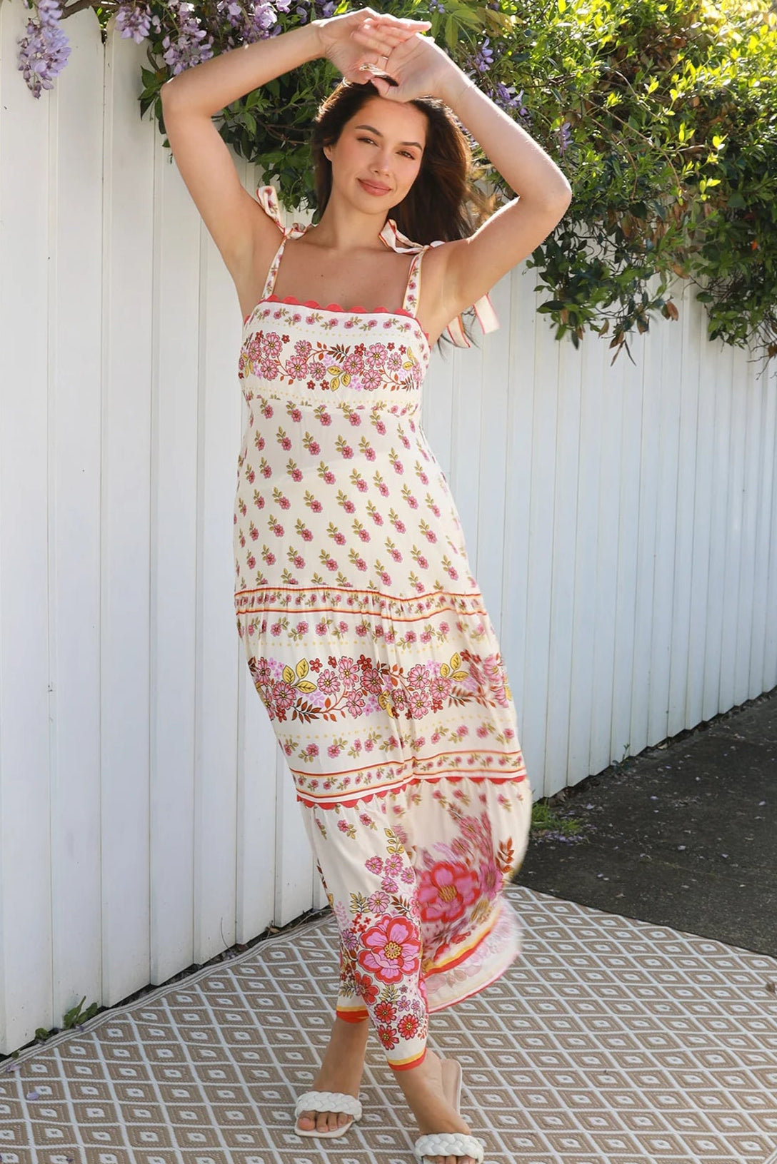 Cream rayon boho maxi dress with blush and rose floral print, tie shoulders, lace trim, and border hemline — Love at First Bloom