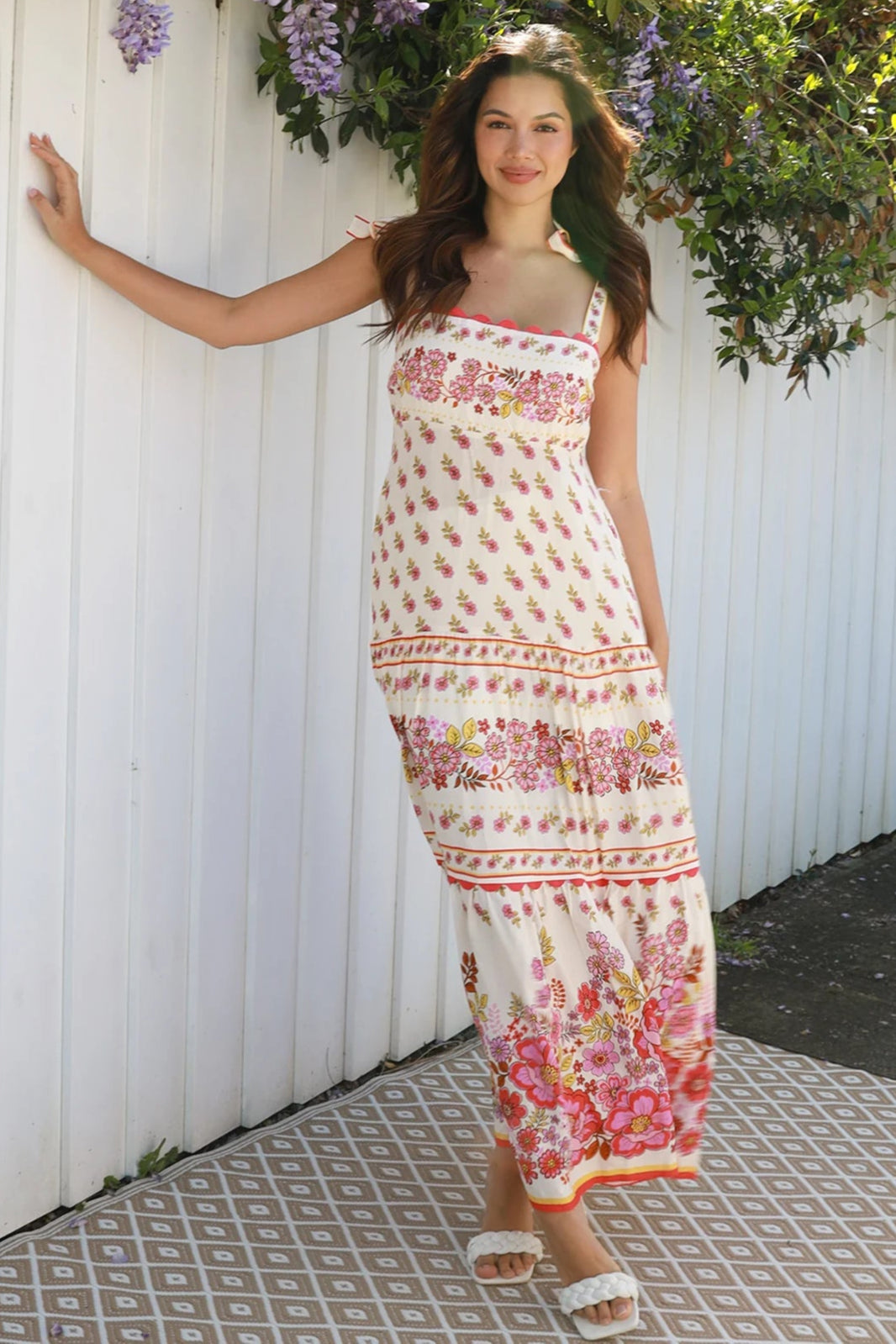 Cream rayon boho maxi dress with blush and rose floral print, tie shoulders, lace trim, and border hemline — Love at First Bloom