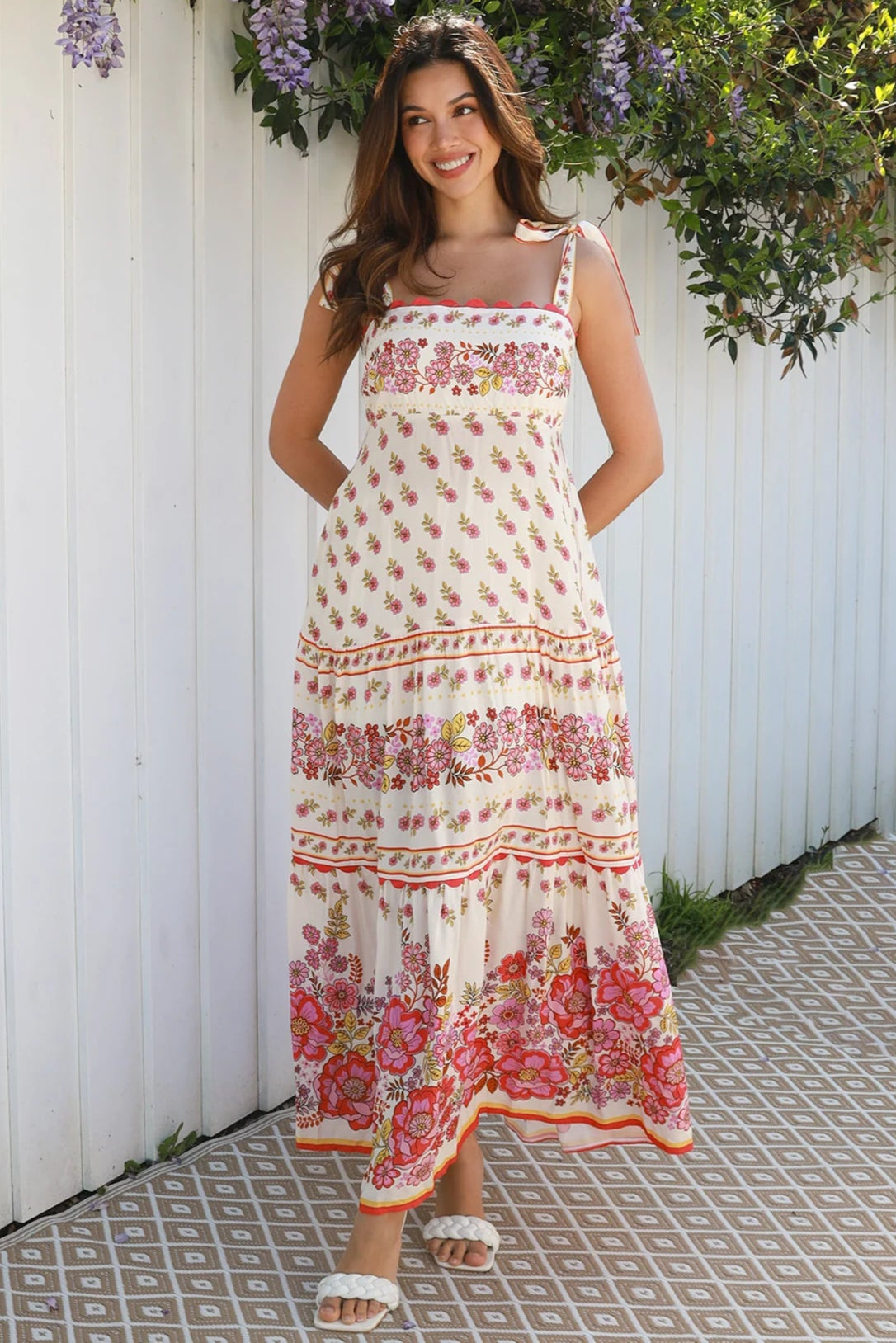 Cream rayon boho maxi dress with blush and rose floral print, tie shoulders, lace trim, and border hemline — Love at First Bloom