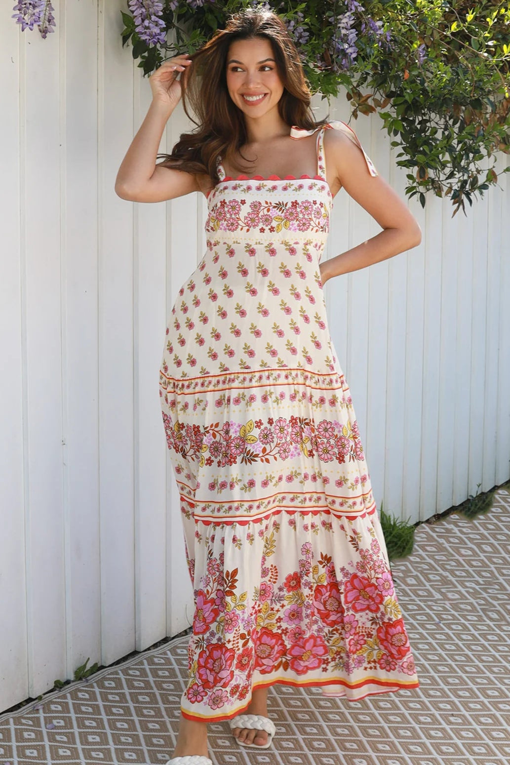 Cream rayon boho maxi dress with blush and rose floral print, tie shoulders, lace trim, and border hemline — Love at First Bloom