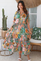 Woman in colourful tropical patchwork rayon midi dress with palms hibiscus and shells - boho chic island style Australia