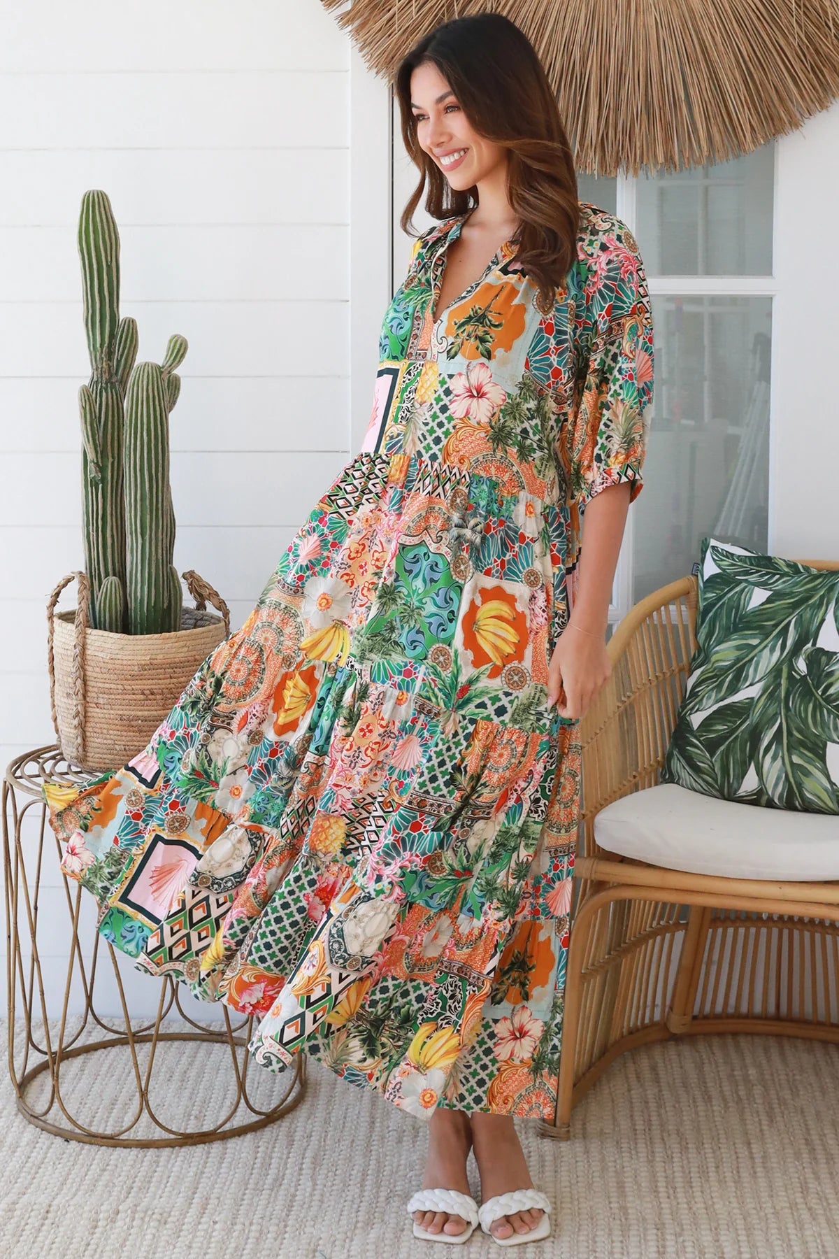 Woman in colourful tropical patchwork rayon midi dress with palms hibiscus and shells - boho chic island style Australia