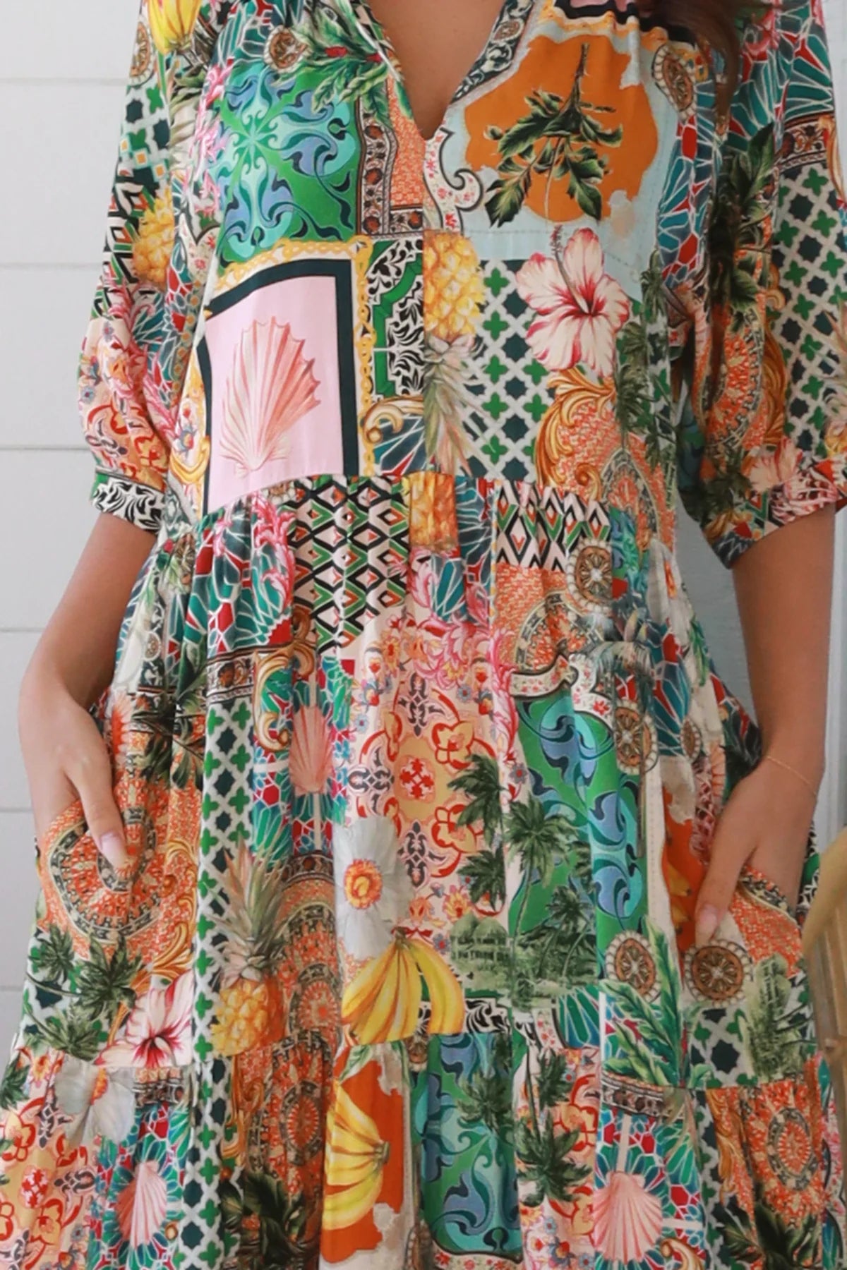 Woman in colourful tropical patchwork rayon midi dress with palms hibiscus and shells - boho chic island style Australia