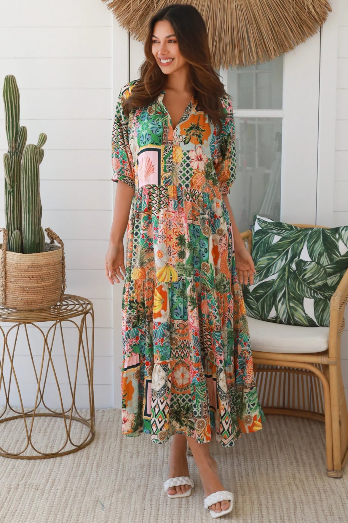 Woman in colourful tropical patchwork rayon midi dress with palms hibiscus and shells - boho chic island style Australia