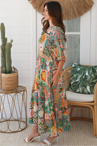 Woman in colourful tropical patchwork rayon midi dress with palms hibiscus and shells - boho chic island style Australia