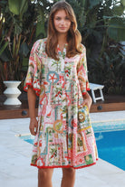 Woman wearing Zimmy tiered mini dress in rayon with button-through front and bohemian print by Salty Palm Australia