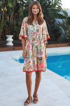 Woman wearing Zimmy tiered mini dress in rayon with button-through front and bohemian print by Salty Palm Australia