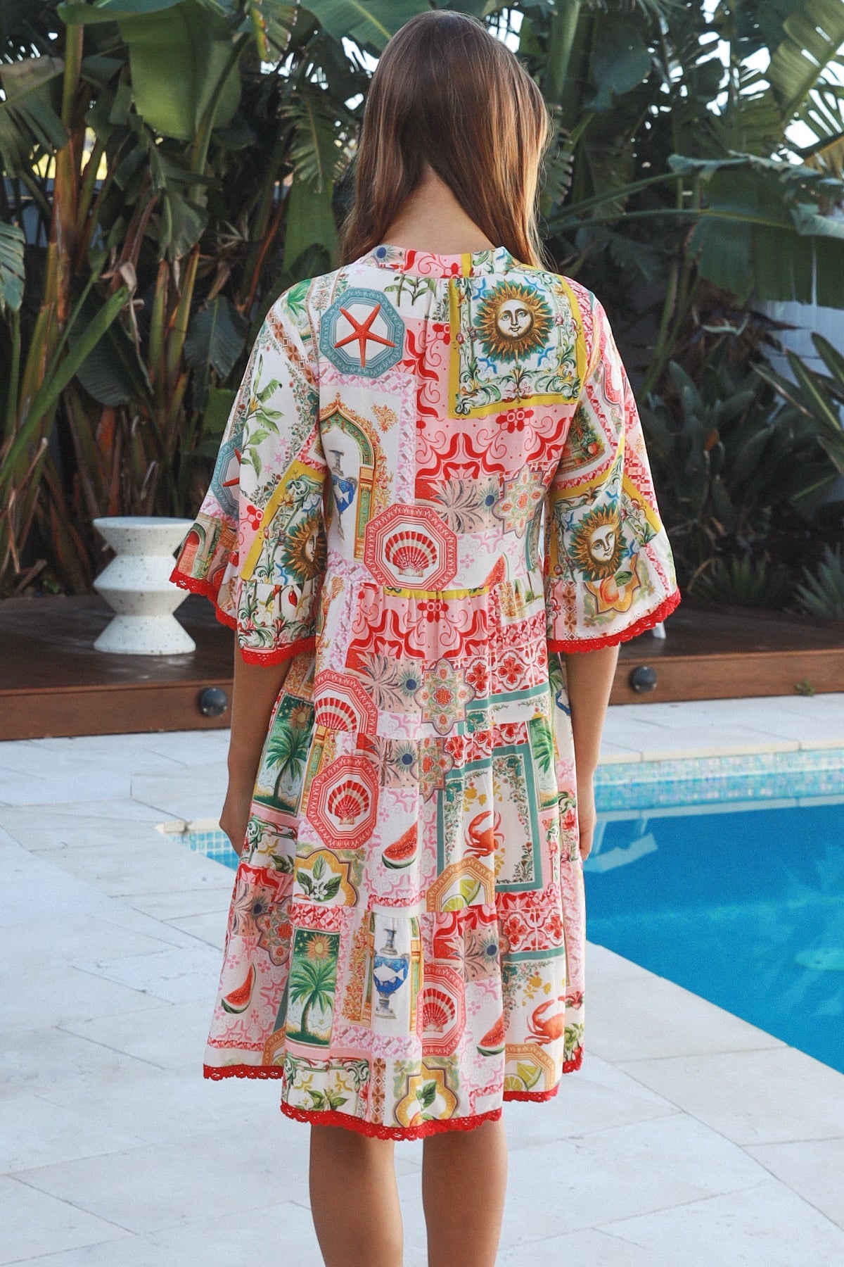 Woman wearing Zimmy tiered mini dress in rayon with button-through front and bohemian print by Salty Palm Australia