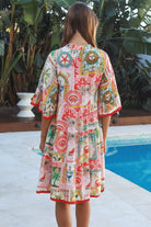 Woman wearing Zimmy tiered mini dress in rayon with button-through front and bohemian print by Salty Palm Australia