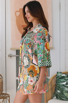 “Woman wearing tropical boho rayon shirt with border sleeves and pleated back – Amira Island Dream Shirt by Dreamcatcher, Bohemian Love Runway”