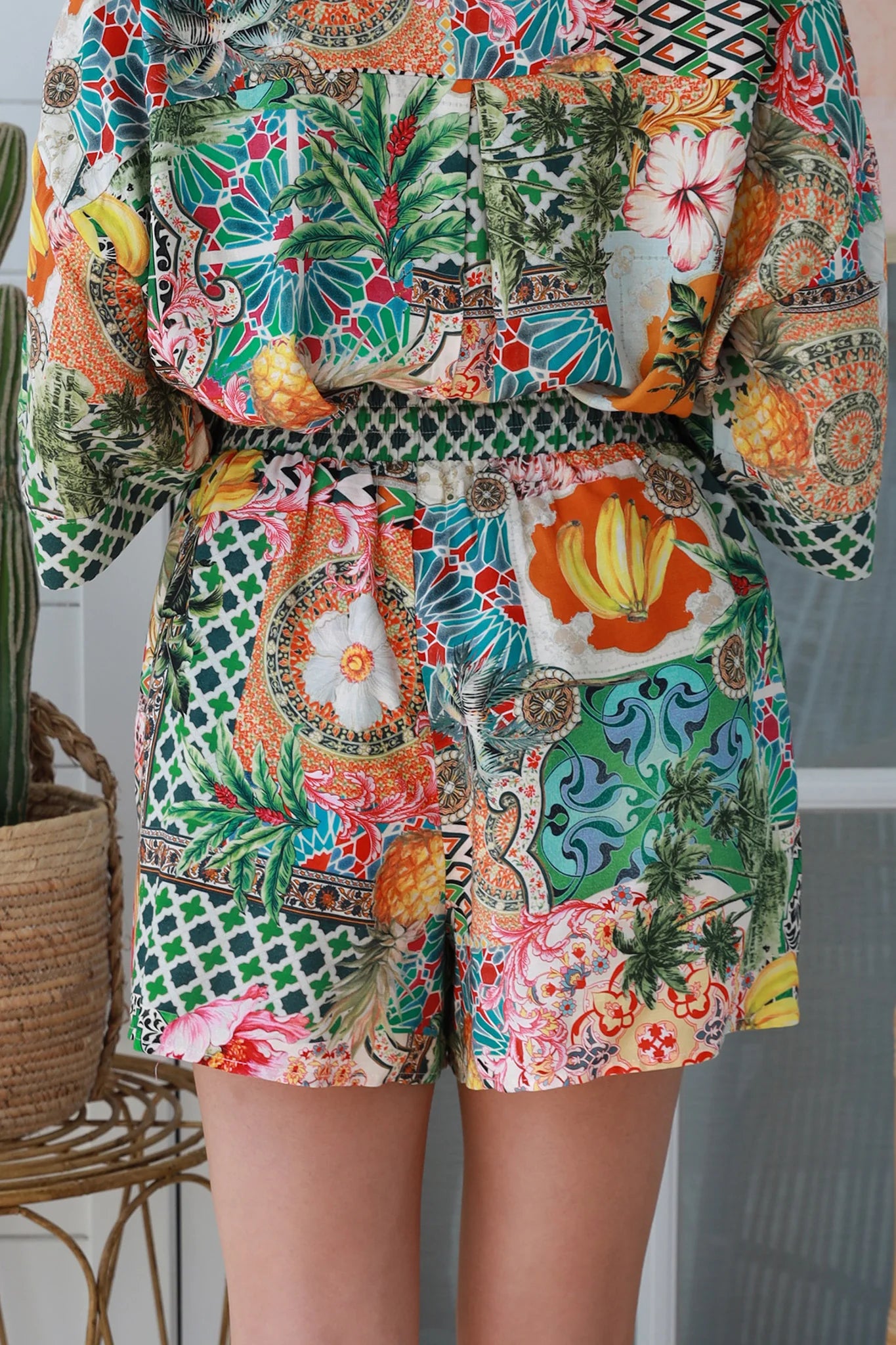 “Woman wearing tropical boho rayon shorts with border waistband and tie front – Amira Island Dream Shorts by Dreamcatcher, Bohemian Love Runway”