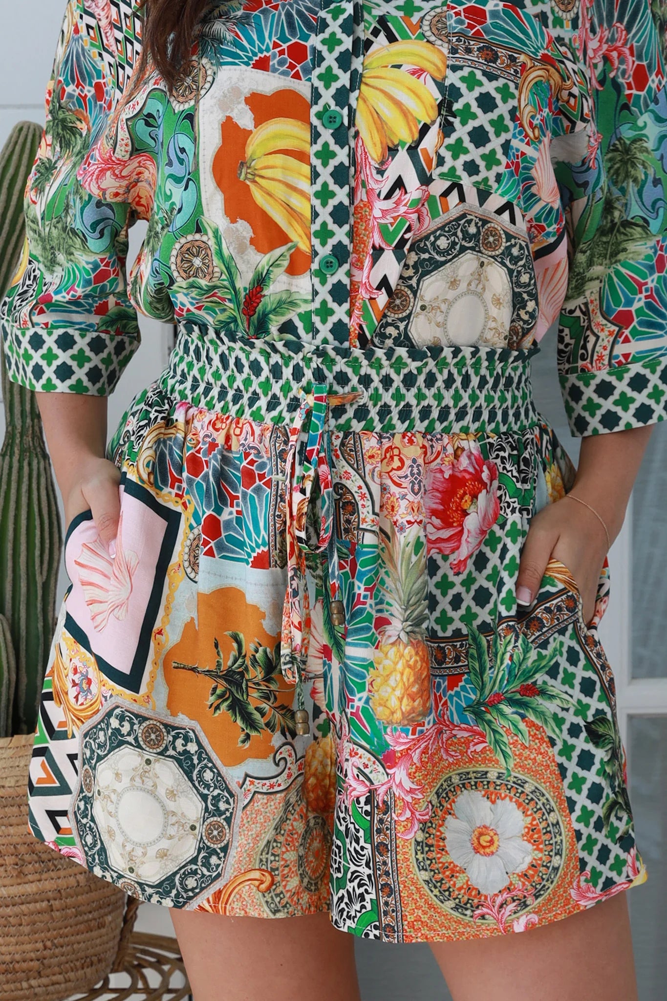 “Woman wearing tropical boho rayon shorts with border waistband and tie front – Amira Island Dream Shorts by Dreamcatcher, Bohemian Love Runway”