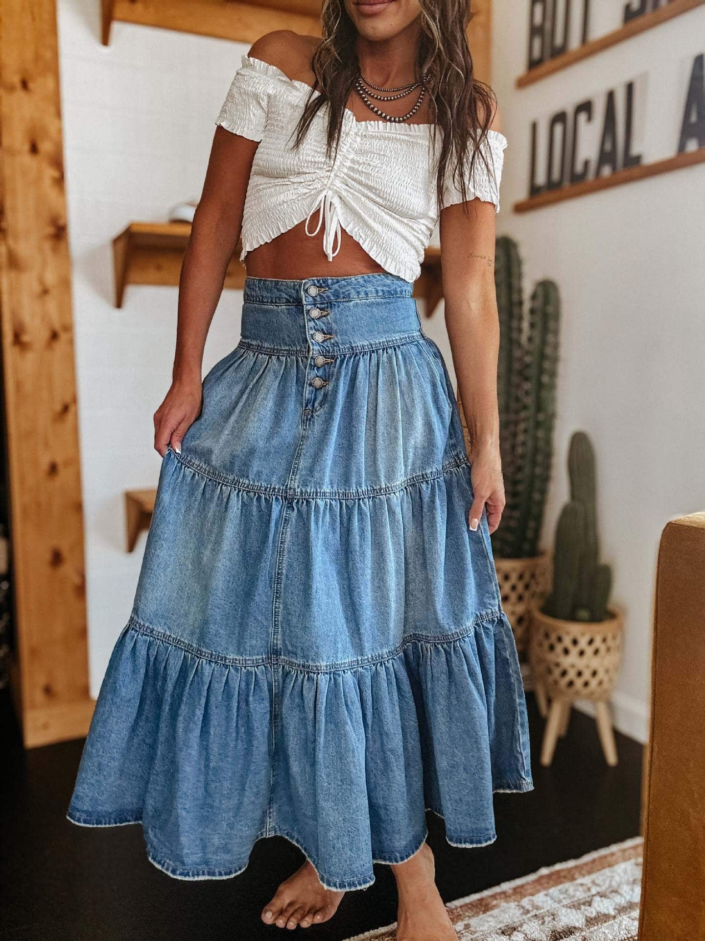 Woman in high-waisted tiered indigo cotton denim maxi skirt with button front - Bohemian Love Runway.
