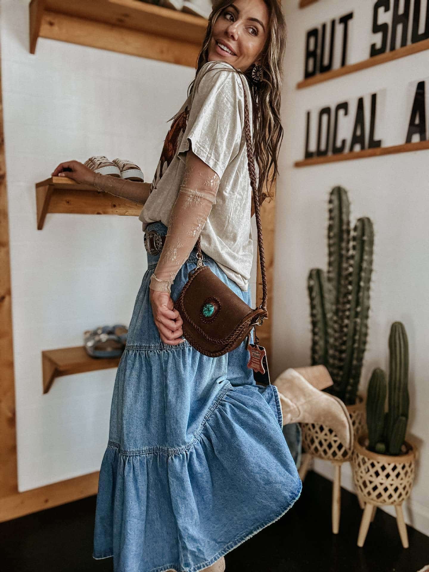 Woman in high-waisted tiered indigo cotton denim maxi skirt with button front - Bohemian Love Runway.