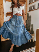 Woman in high-waisted tiered indigo cotton denim maxi skirt with button front - Bohemian Love Runway.