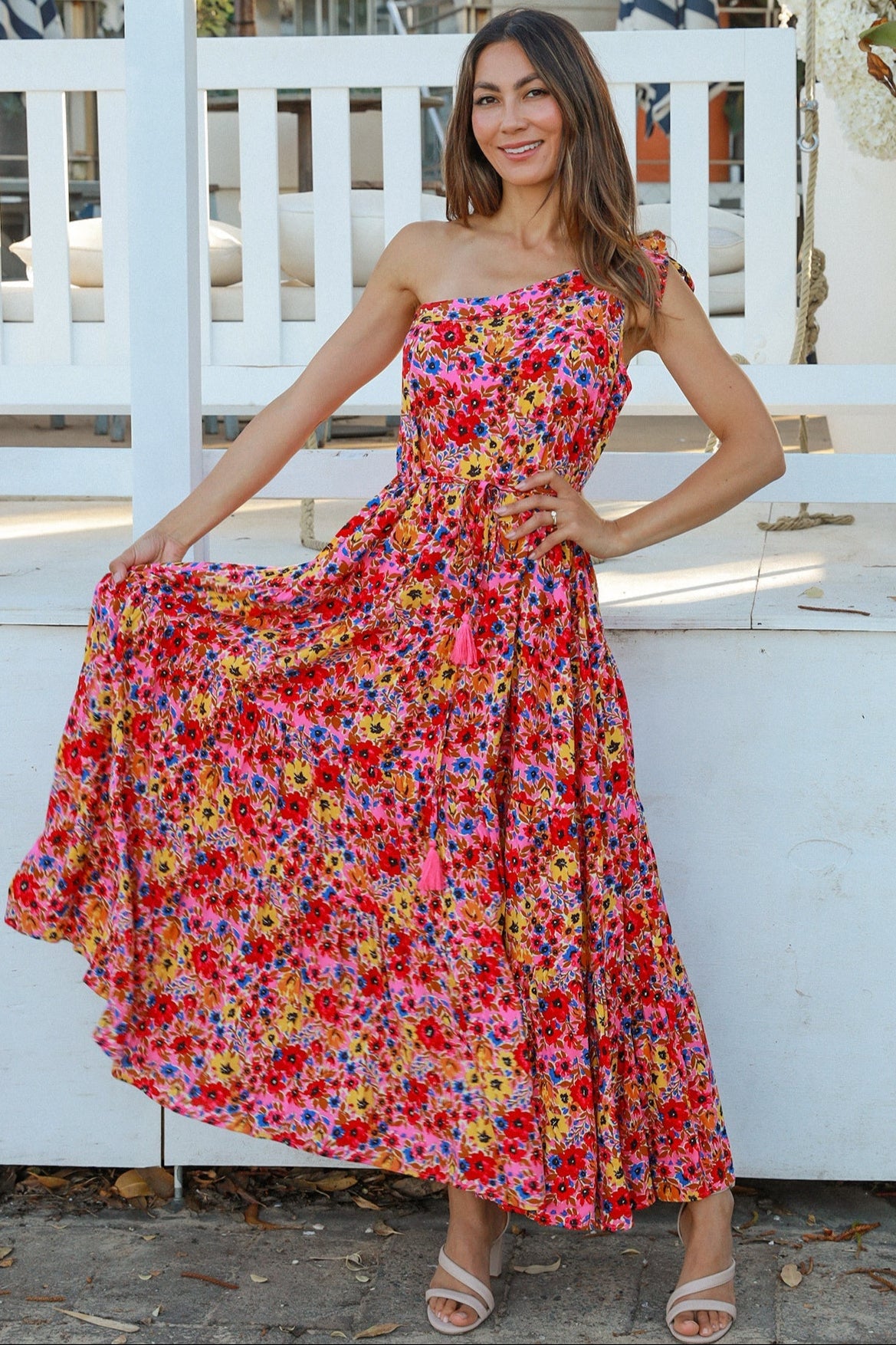 Women wearing a one-shoulder floral boho maxi dress with tassel waist tie - Lyric dress Australian summer fashion.
