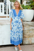 Woman in blue floral rayon bohemian midi dress with V-neckline flutter sleeves pockets and border frill hemline — Australia