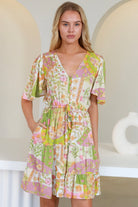“Woman in vintage floral patchwork mini dress with flutter sleeves and drawstring waist – boho dresses Australia”