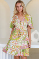 “Woman in vintage floral patchwork mini dress with flutter sleeves and drawstring waist – boho dresses Australia”