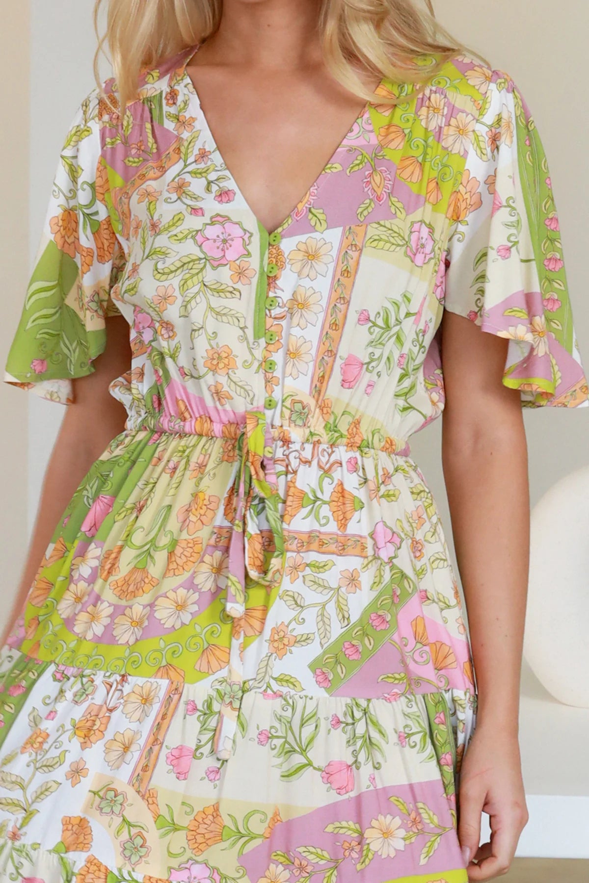 “Woman in vintage floral patchwork mini dress with flutter sleeves and drawstring waist – boho dresses Australia”