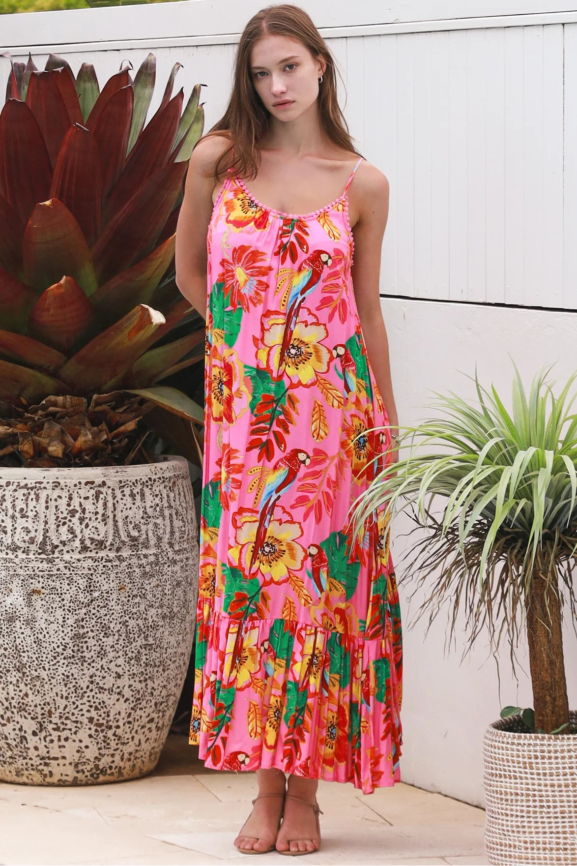 Pink floral slip maxi dress with poppy and parrot print, adjustable shoestring straps and crochet trim neckline