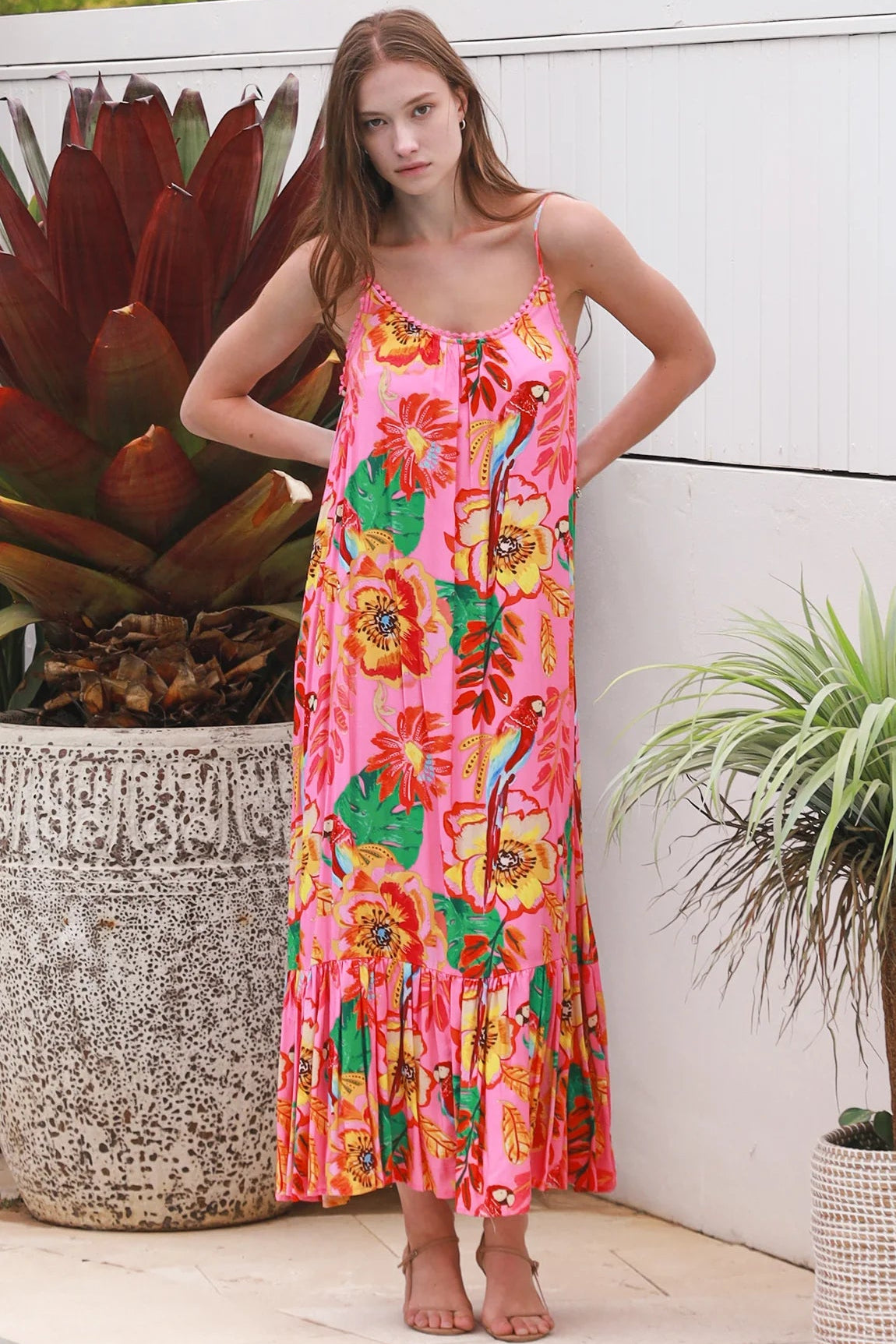 Pink floral slip maxi dress with poppy and parrot print, adjustable shoestring straps and crochet trim neckline