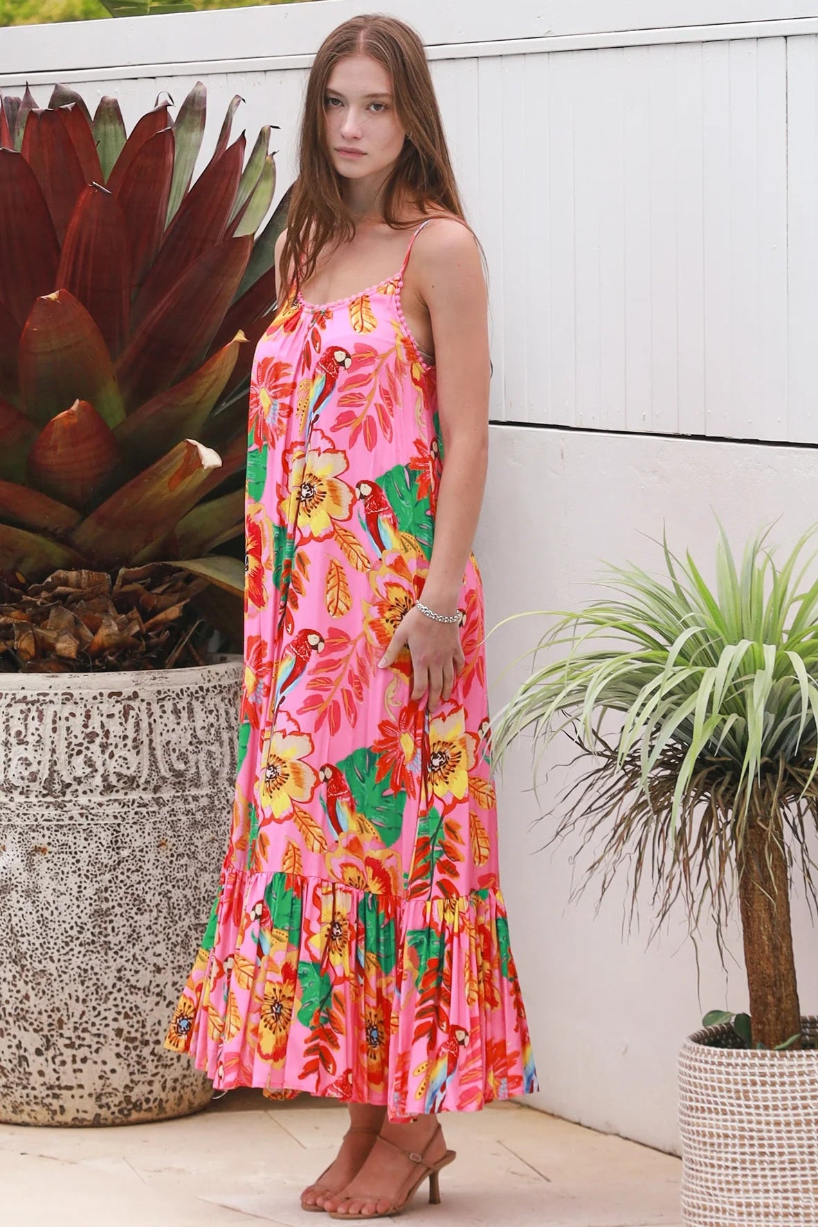 Pink floral slip maxi dress with poppy and parrot print, adjustable shoestring straps and crochet trim neckline