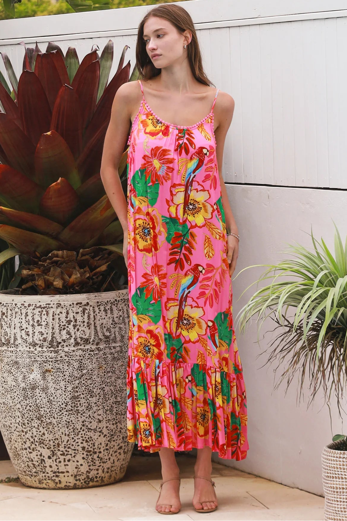 Pink floral slip maxi dress with poppy and parrot print, adjustable shoestring straps and crochet trim neckline