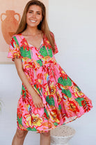 Pink floral mini dress with poppy and parrot print, V-neck button bodice, tassel ties and flutter sleeves