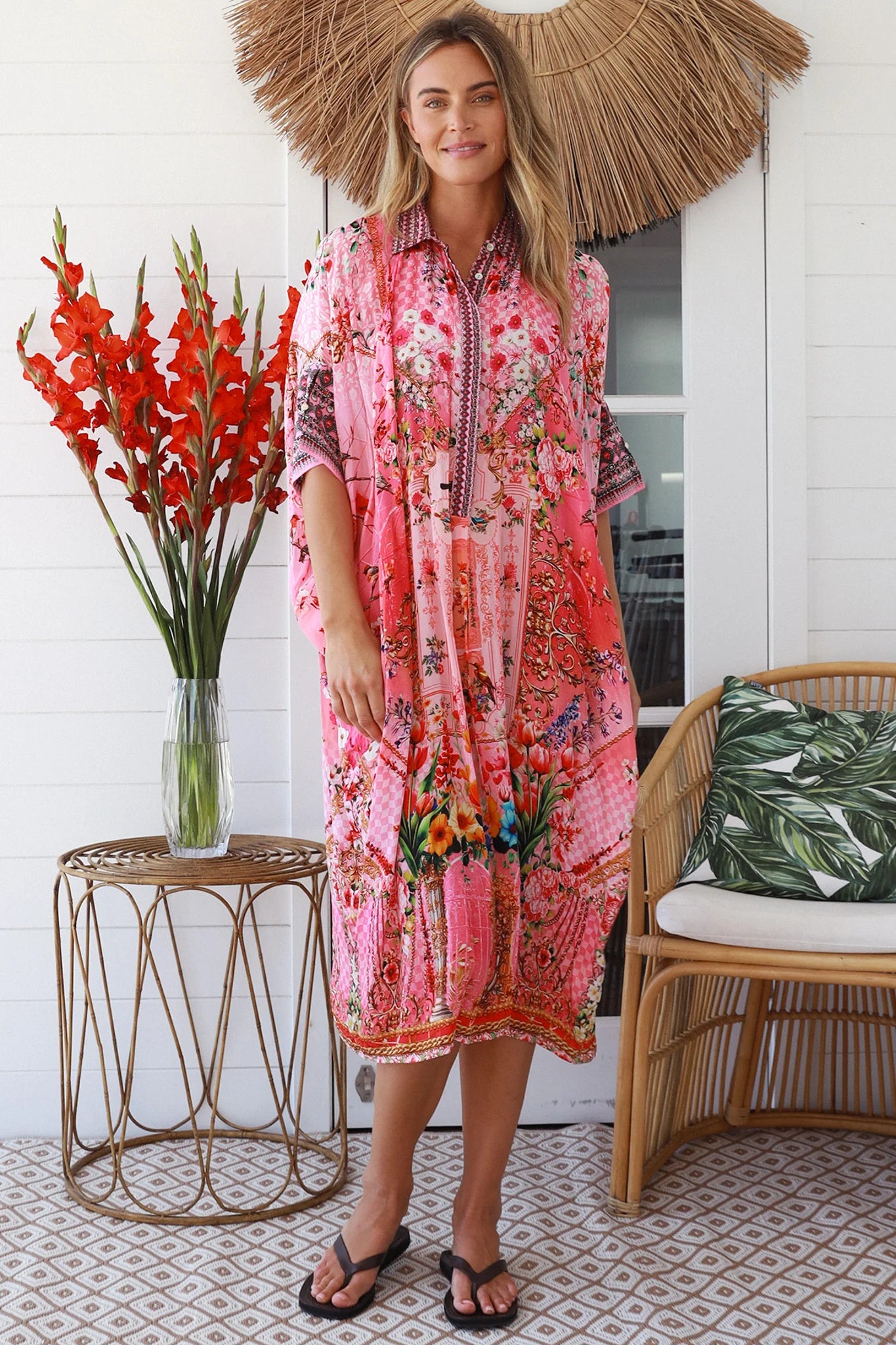 “Woman in pink floral viscose crepe kaftan midi dress with rhinestone buttons by Peacock Feathers – bohemian resort wear Australia”