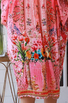 “Woman in pink floral viscose crepe kaftan midi dress with rhinestone buttons by Peacock Feathers – bohemian resort wear Australia”