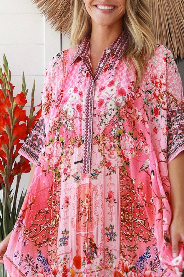 “Woman in pink floral viscose crepe kaftan midi dress with rhinestone buttons by Peacock Feathers – bohemian resort wear Australia”